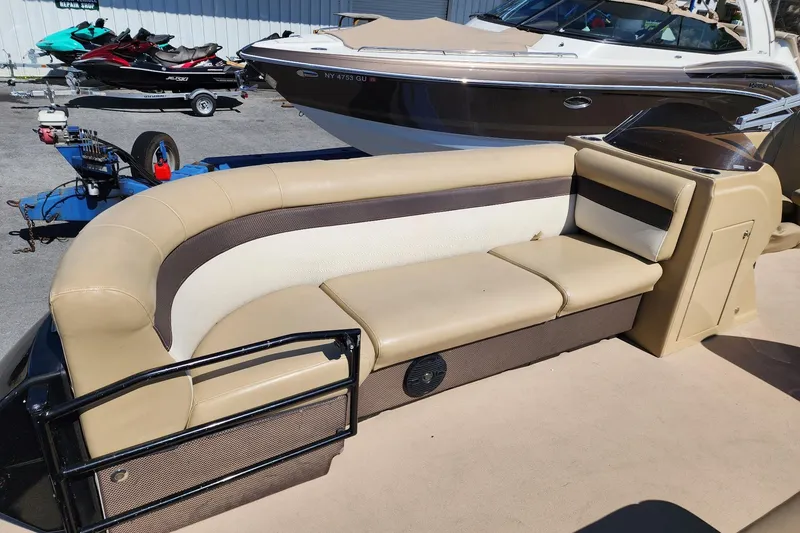 Slide: The Image of 2017 Larson Escape RT 2400 Cruise Triple pontoon boat with beige seating. - 13