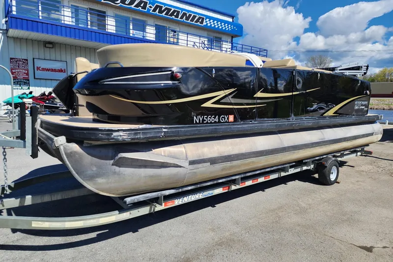 Slide: The Image of 2017 Larson Escape RT 2400 Cruise Triple pontoon boat on trailer, parked outside dealership. - 3