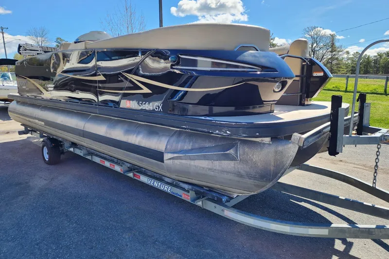 Slide: The Image of 2017 Larson Escape RT 2400 Cruise Triple pontoon boat on trailer, sunny day. - 4