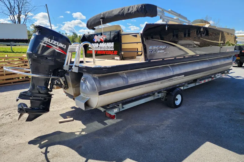 Slide: The Image of 2017 Larson Escape RT 2400 Cruise Triple pontoon boat with Suzuki outboard motor on trailer. - 5