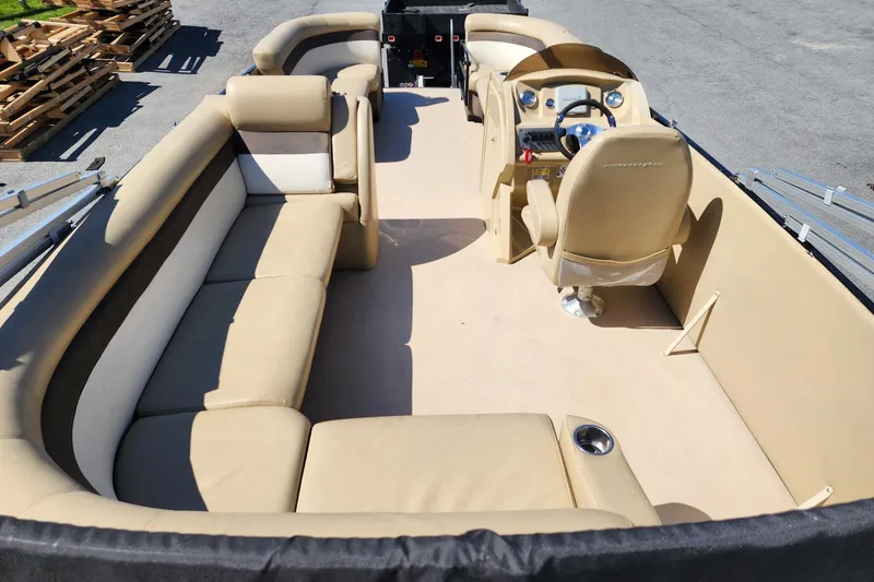 Slide: The Image of Interior view of 2017 Larson Escape RT 2400 Cruise Triple pontoon boat with beige seating. - 8