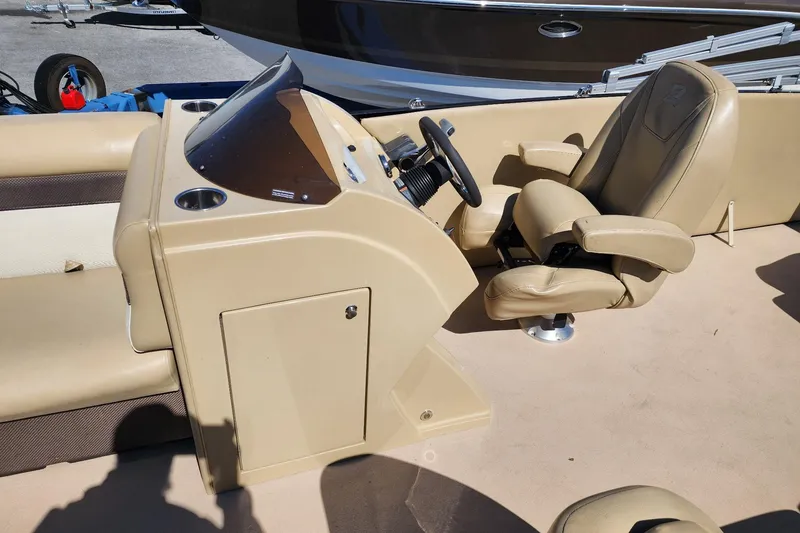 Slide: The Image of 2017 Larson Escape RT 2400 Cruise Triple boat interior with beige captain's chair and console. - 9
