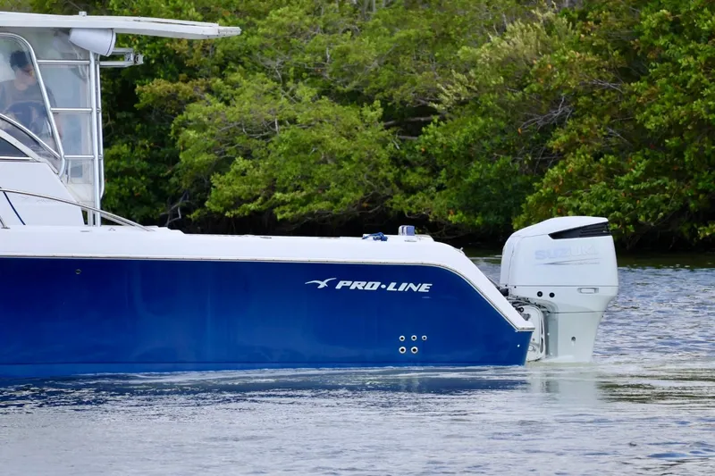 Slide: The Image of 2002 Pro-Line 32 Express boat with Suzuki outboard motor on water. - 3