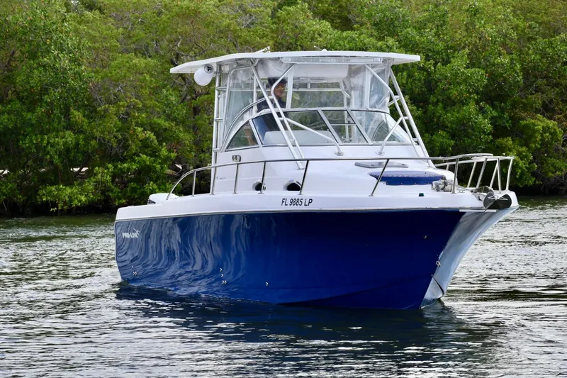 Slide: The Image of 2002 Pro-Line 32 Express boat on water, surrounded by lush greenery. - 4