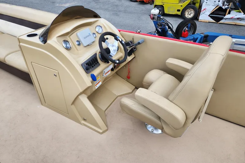 Slide: The Image of 2017 Larson Escape RT 2400 Cruise Triple boat helm with beige captain's chair and controls. - 10
