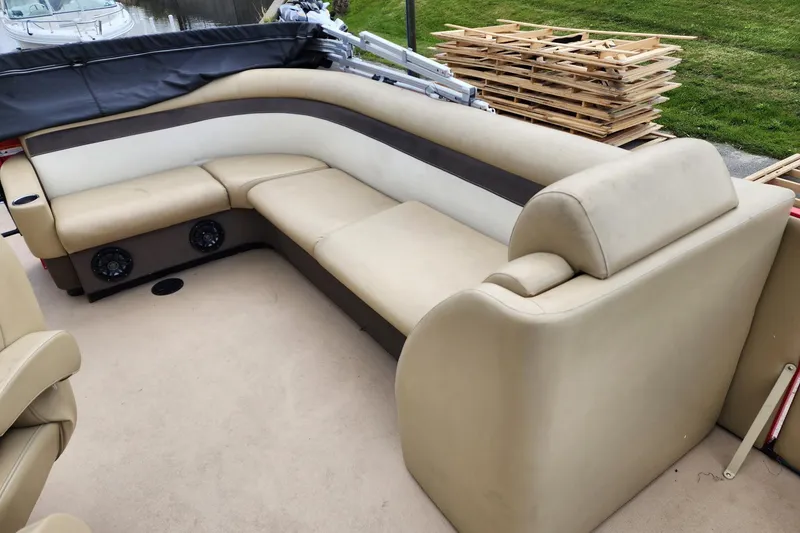 Slide: The Image of 2017 Larson Escape RT 2400 Cruise Triple boat with beige seating and built-in speakers. - 13