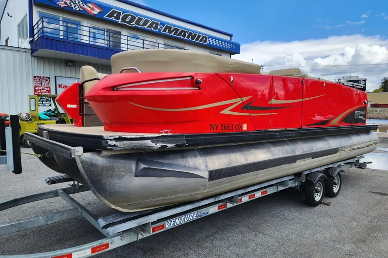 Slide: The Image of 2017 Larson Escape RT 2400 Cruise Triple pontoon boat on trailer outside dealership. - 3