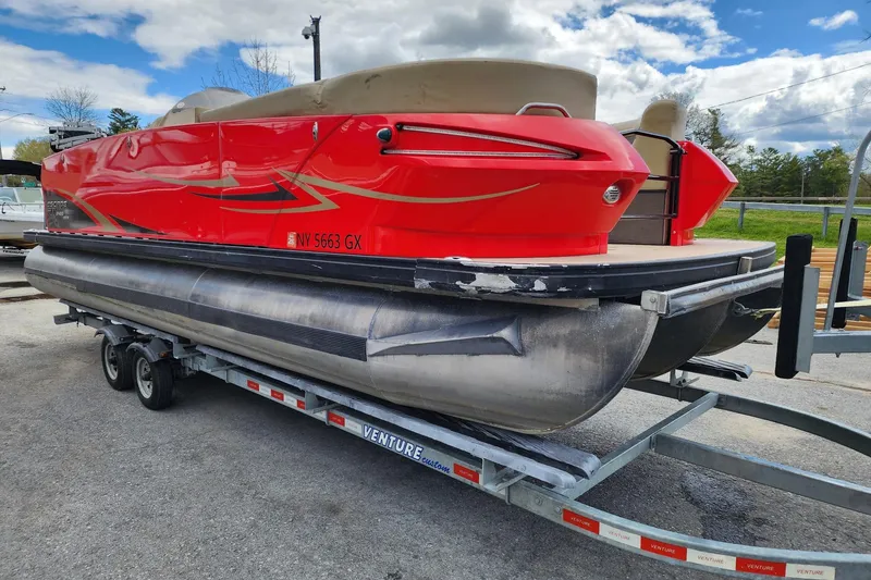 Slide: The Image of 2017 Larson Escape RT 2400 Cruise Triple pontoon boat on trailer, vibrant red exterior. - 4
