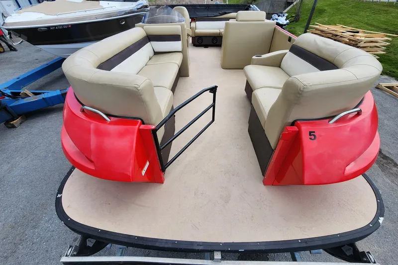 Slide: The Image of 2017 Larson Escape RT 2400 Cruise Triple pontoon boat with beige seating and red accents. - 5