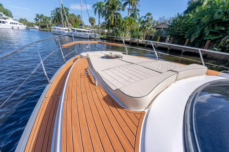Slide: The Image of Manufacturer Provided Image: Luxurious Hanover 415 yacht deck with sunbed, docked near lush greenery, 2025 model. - 4