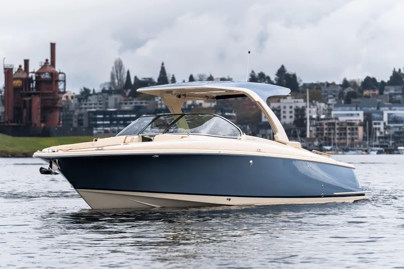 The Image of 2025 Chris-Craft Launch 31 GT boat on water, urban skyline background. - 0