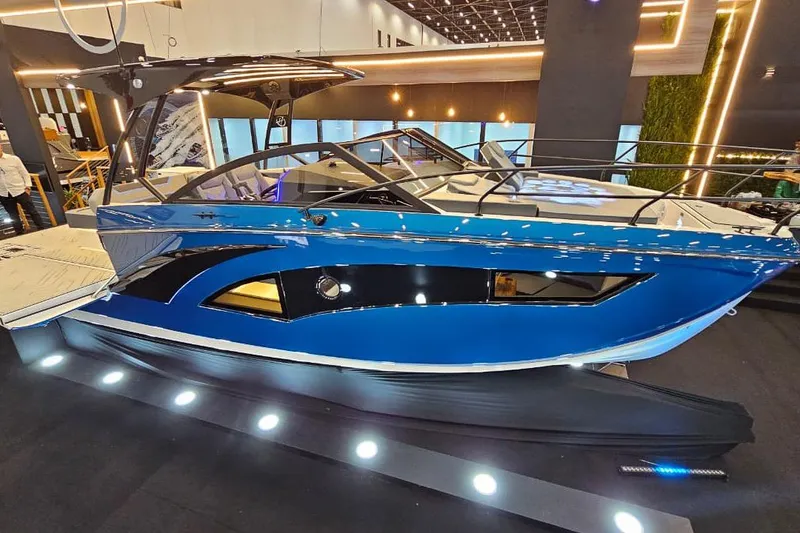 Slide: The Image of 2027 Hanover 327 boat displayed indoors with sleek blue design and modern features. - 14