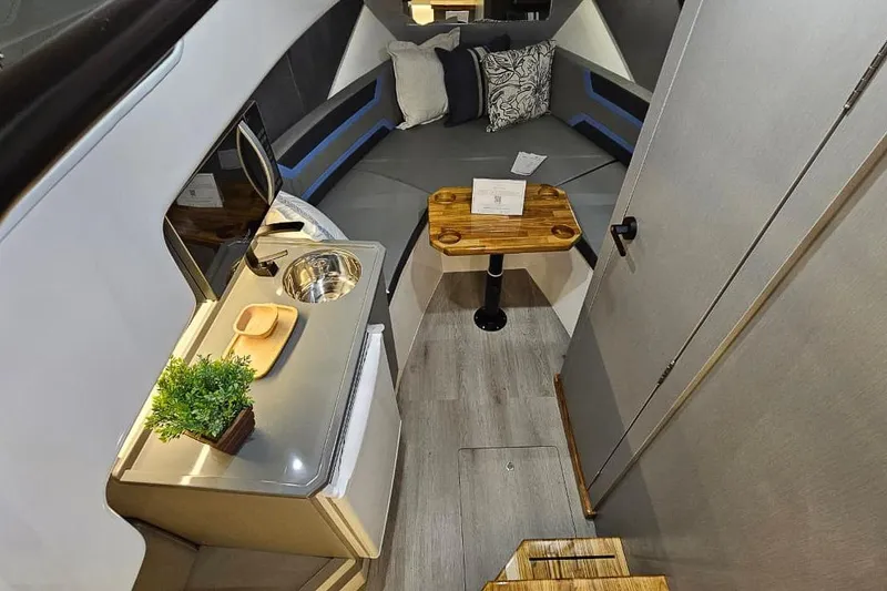 Slide: The Image of Interior of 2027 Hanover 327 boat with modern seating, kitchenette, and wooden table. - 17