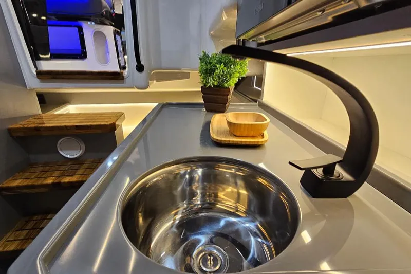 Slide: The Image of Modern kitchen sink in Hanover 327 RV, featuring sleek faucet and wooden accents, 2027 model. - 8