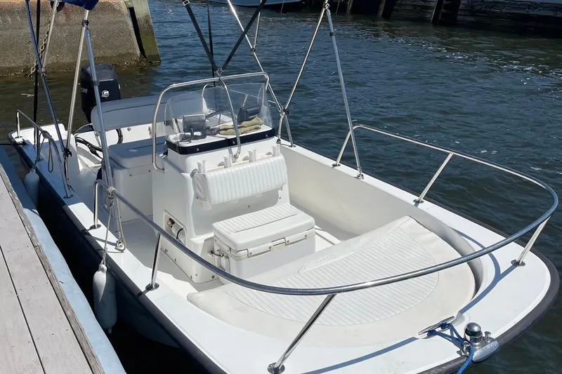 Slide: The Image of 2009 Boston Whaler 150 Montauk boat docked on calm water. - 2