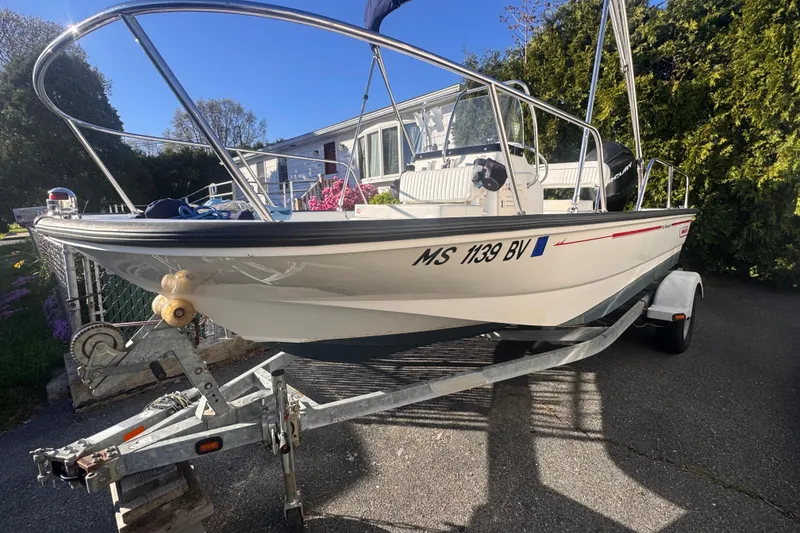 Slide: The Image of 2009 Boston Whaler 150 Montauk boat on trailer, parked in driveway. - 4