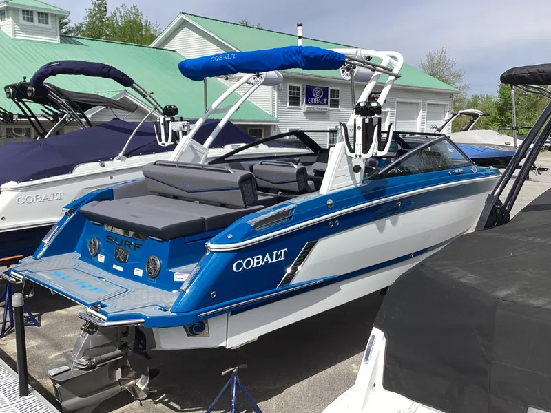 Slide: The Image of 2026 Cobalt R4 Surf boat in blue and white on a lot. - 3