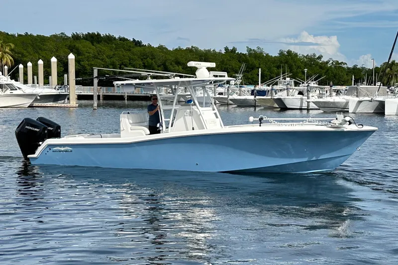 The Image of 2021 Invincible 33 Open Fisherman boat on calm water near a marina. - 1
