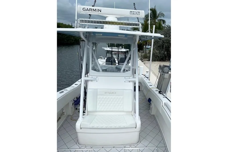 Slide: The Image of 2021 Invincible 33 Open Fisherman boat with Garmin equipment, docked by a serene waterway. - 11