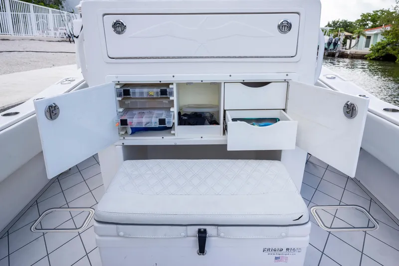 Slide: The Image of 2021 Invincible 33 Open Fisherman boat storage compartments with fishing gear and tackle boxes. - 17