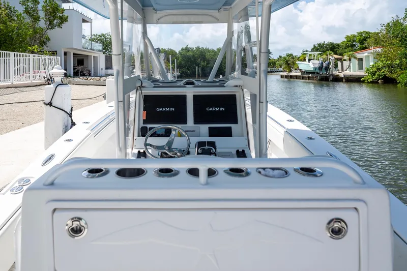 Slide: The Image of 2021 Invincible 33 Open Fisherman boat with Garmin navigation, docked by a scenic canal. - 23