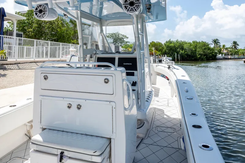 Slide: The Image of 2021 Invincible 33 Open Fisherman boat with modern console and seating, docked by the water. - 25