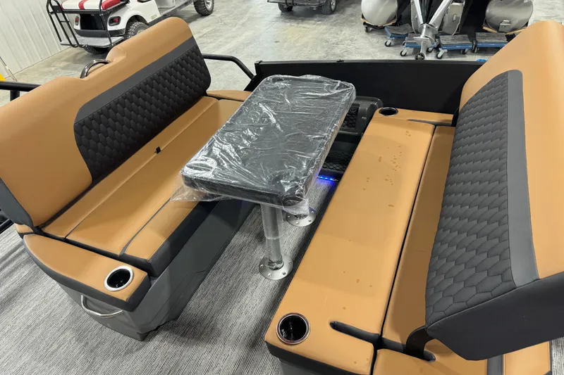 Slide: The Image of 2026 Sylvan L5 DLZ boat interior with tan and black seating, table, and cup holders. - 10