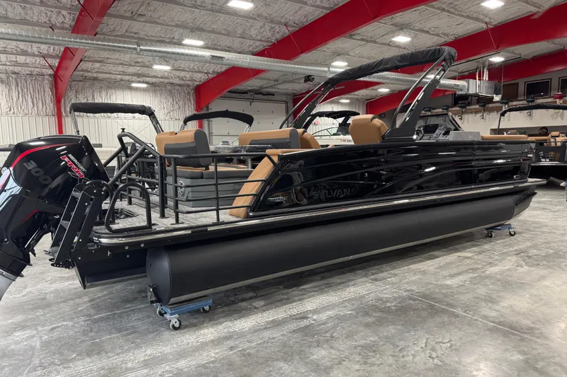 Slide: The Image of 2026 Sylvan L5 DLZ pontoon boat in showroom, featuring sleek black design and powerful outboard motor. - 4