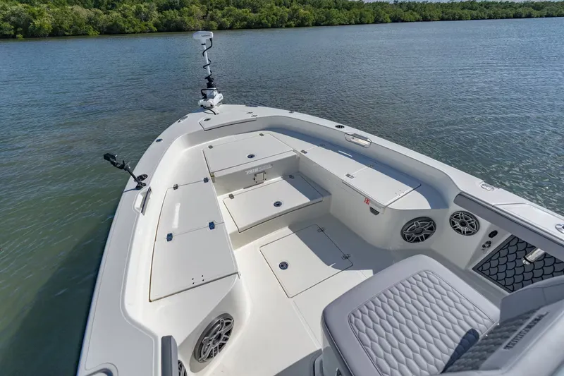 Slide: The Image of 2026 Pathfinder 2800 Hybrid boat on calm water with green shoreline. - 15