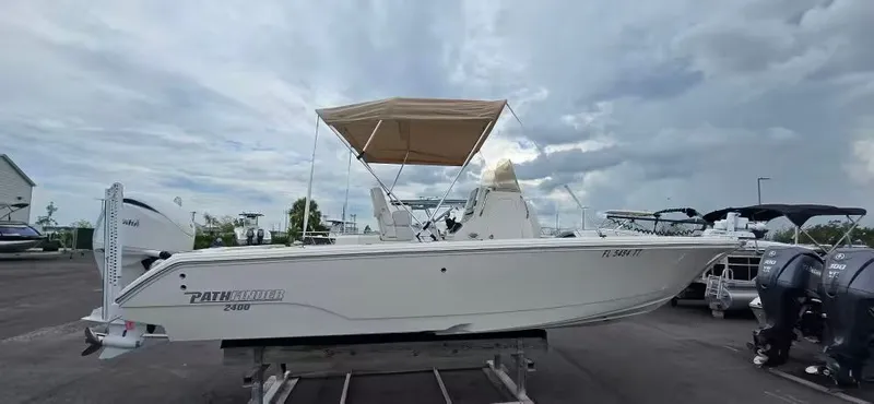 The Image of 2024 Pathfinder 2400 Open boat with canopy in a parking lot. - 1