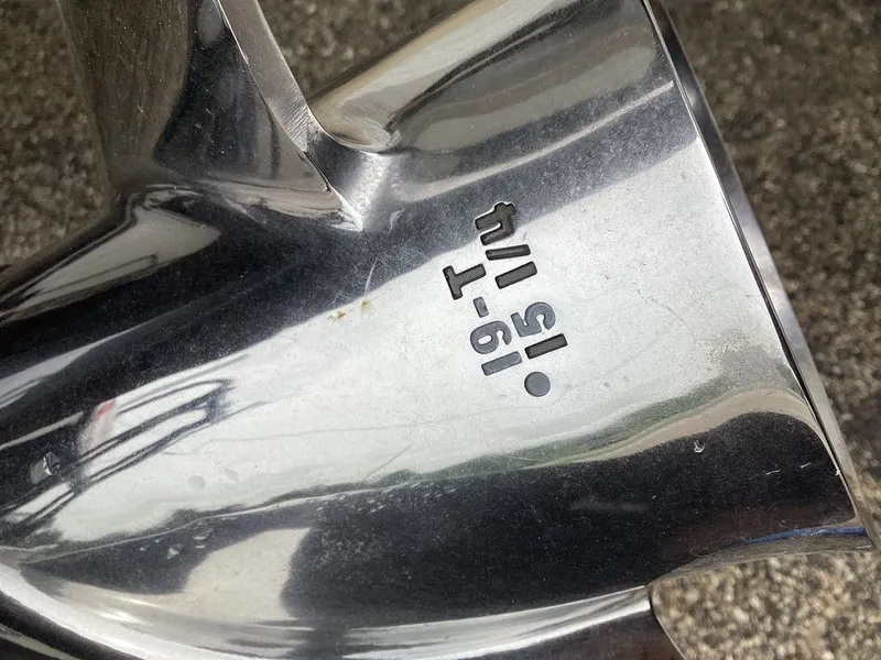 Slide: The Image of Close-up of a shiny boat propeller with engraved markings. - 4