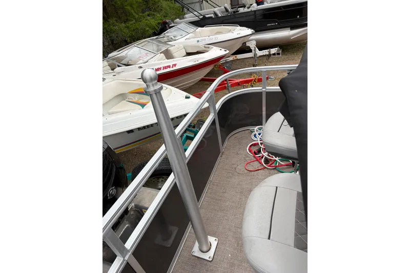 Slide: The Image of 2023 Ranger 220FC boat interior with seating and railing, surrounded by other boats. - 11