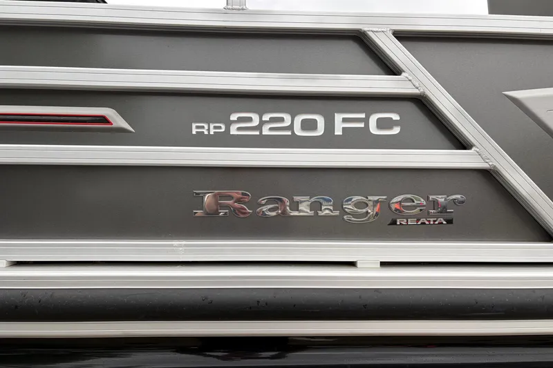 Slide: The Image of 2023 Ranger 220FC boat logo on sleek metallic surface. - 5