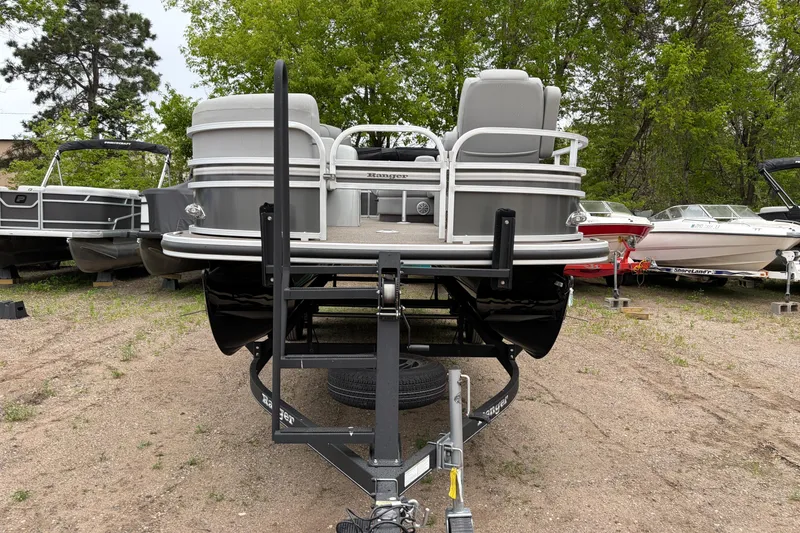 Slide: The Image of 2023 Ranger 220FC pontoon boat on trailer, surrounded by trees and other boats. - 6