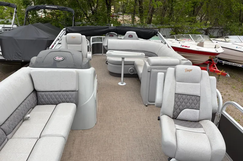 Slide: The Image of 2023 Ranger 220FC pontoon boat with spacious seating and modern design, docked outdoors. - 8