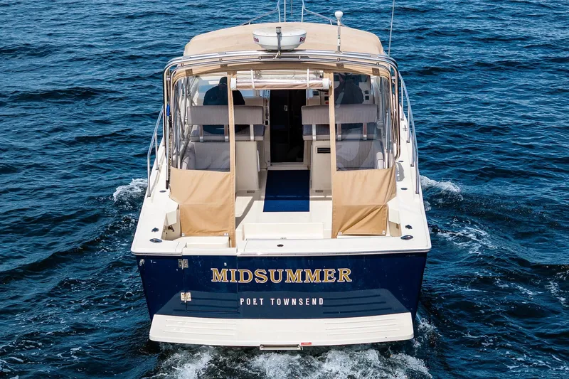 Slide: The Image of 2004 Mainship Pilot 34 boat named "Midsummer" cruising on open water. - 12
