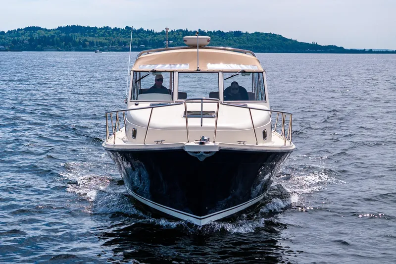 Slide: The Image of 2004 Mainship Pilot 34 cruising on open water, scenic background. - 13