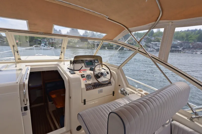 Slide: The Image of 2004 Mainship Pilot 34 boat interior with helm, steering wheel, and water view. - 18