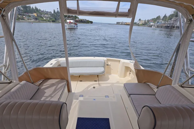 Slide: The Image of 2004 Mainship Pilot 34 boat interior with waterfront view, featuring comfortable seating. - 23