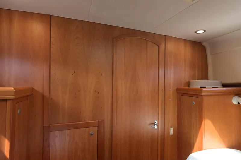 Slide: The Image of Interior of 2004 Mainship Pilot 34, featuring polished wooden cabinetry and soft lighting. - 32
