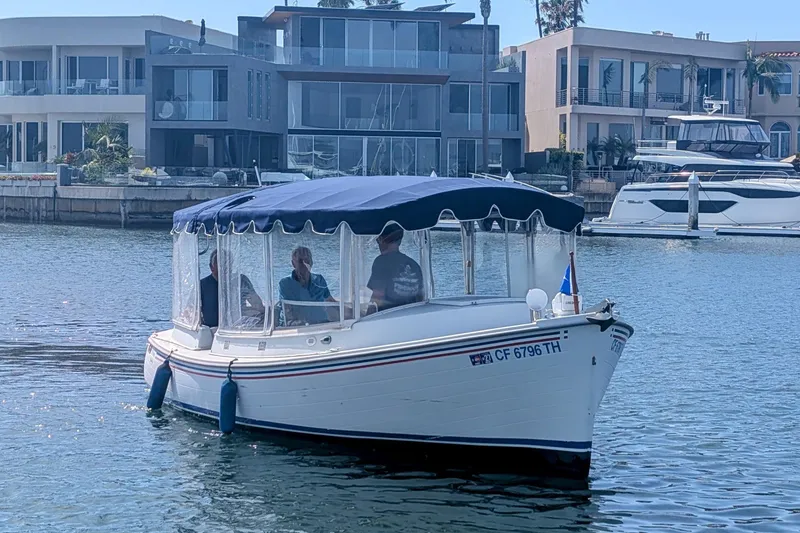 The Image of 2007 Duffy Cuddy Cabin 22 boat cruising near modern waterfront homes. - 1