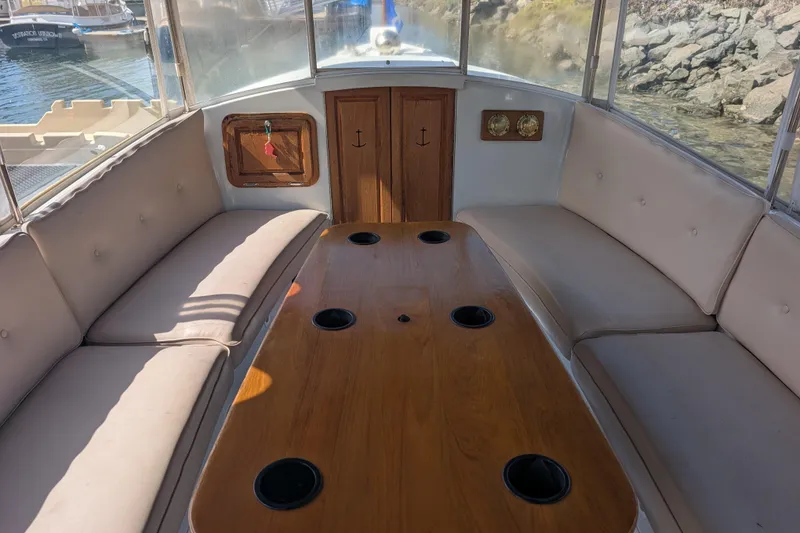 Slide: The Image of Interior of 2007 Duffy Cuddy Cabin 22 boat with cushioned seating and wooden table. - 10