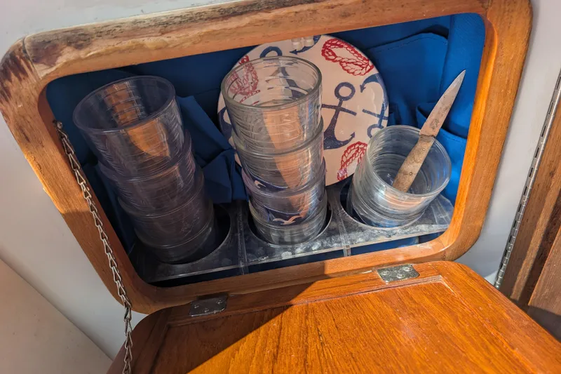 Slide: The Image of Wooden cabinet on 2007 Duffy Cuddy Cabin 22, storing cups, knife, and nautical-themed plate. - 12