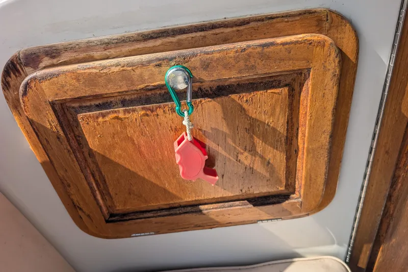 Slide: The Image of Wooden panel with a red keychain on a 2007 Duffy Cuddy Cabin 22 boat. - 13