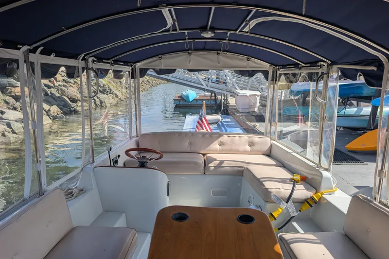 Slide: The Image of 2007 Duffy Cuddy Cabin 22 interior with seating, steering wheel, and dock view. - 14