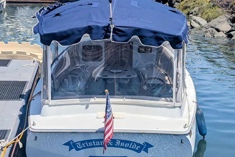 Slide: The Image of 2007 Duffy Cuddy Cabin 22 boat docked with blue canopy and American flag. - 2