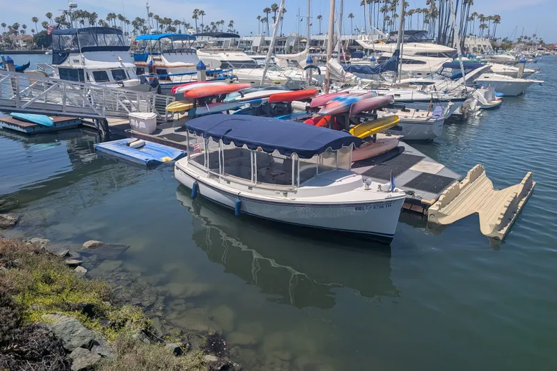 Slide: The Image of 2007 Duffy Cuddy Cabin 22 docked at a marina with other boats and kayaks. - 21