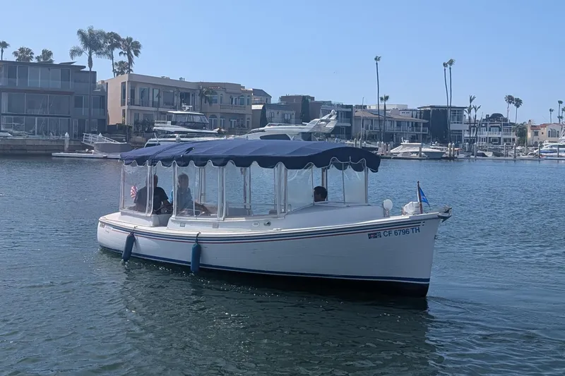 Slide: The Image of 2007 Duffy Cuddy Cabin 22 boat cruising in a marina with waterfront homes in the background. - 4