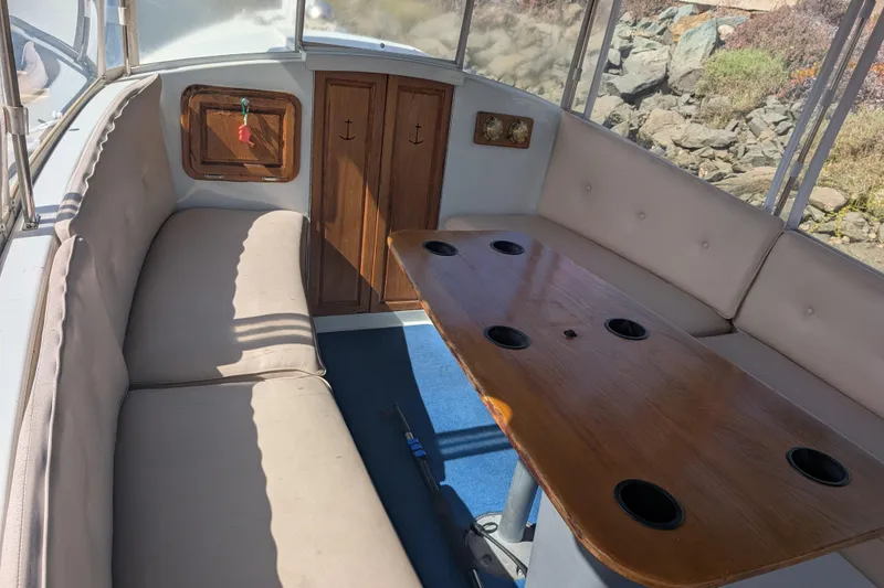 Slide: The Image of Interior of a 2007 Duffy Cuddy Cabin 22 with cushioned seating and wooden table. - 5