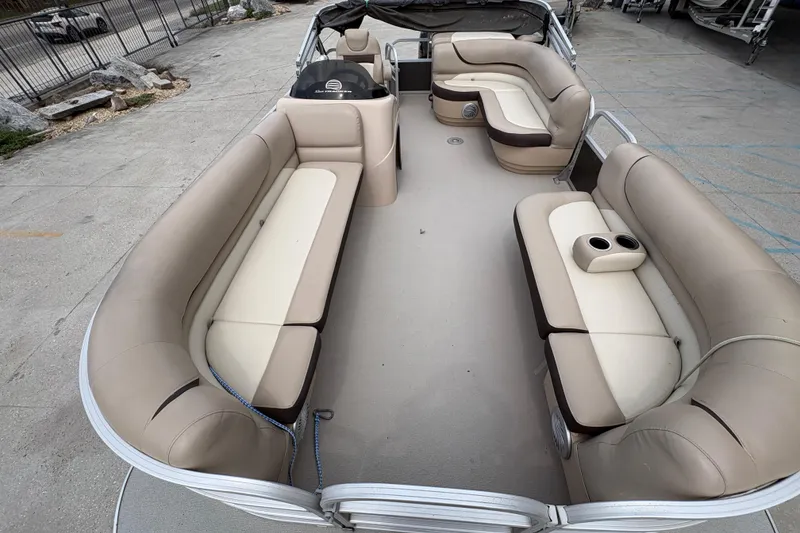 Slide: The Image of 2016 Sun Tracker Party Barge 20 DLX interior with beige seating and cup holders. - 11